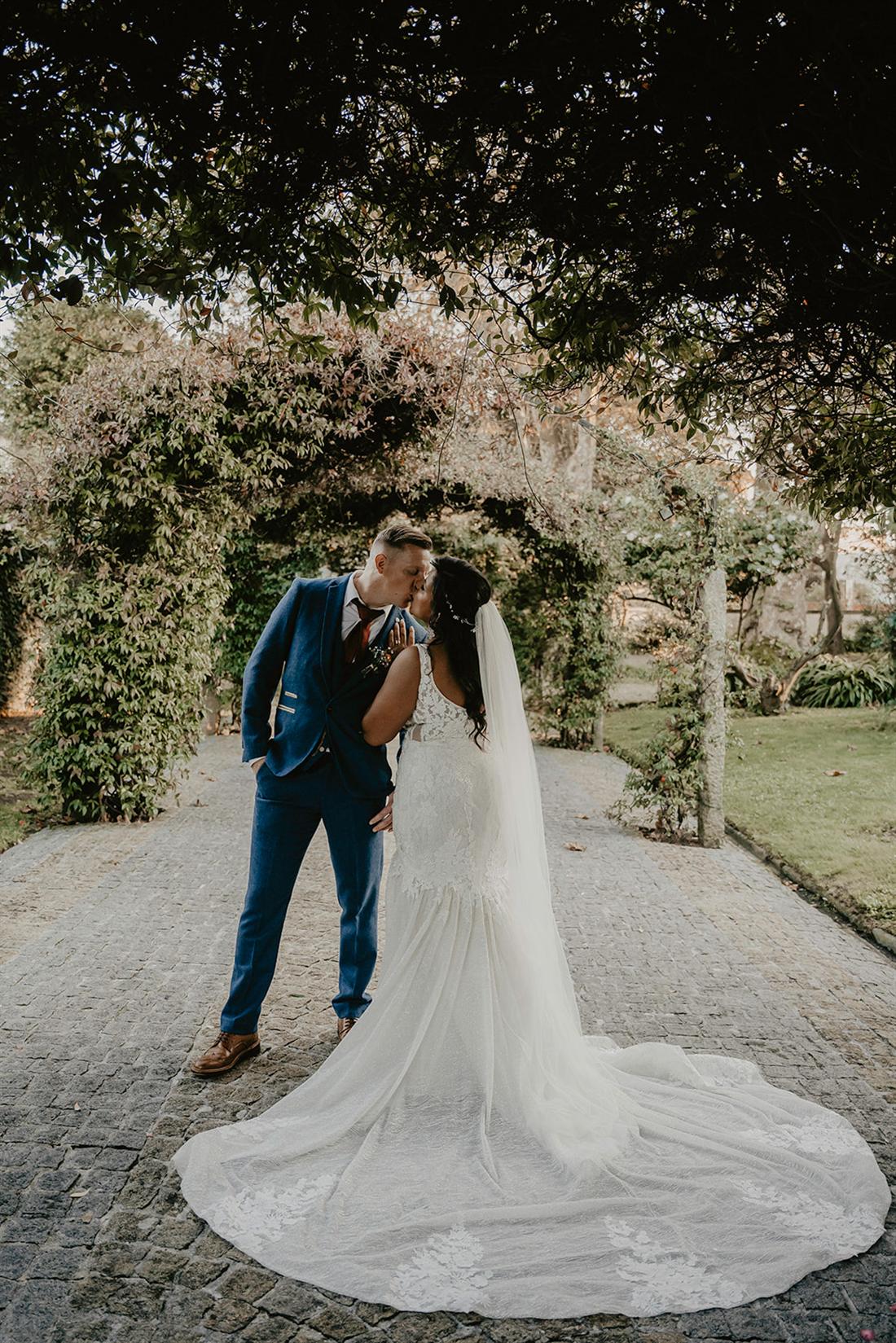 Casal se beijando sob um arco de jardim